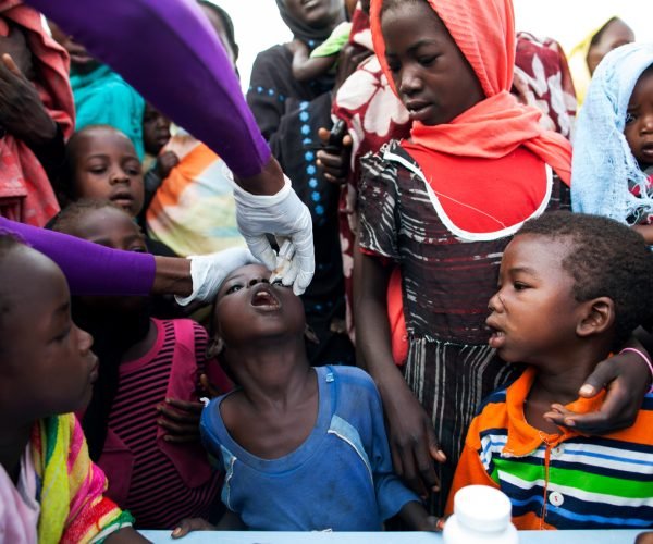 7 April 2014. Khor Abeche: A nurse from the NGO World Vision provides polio vaccination given by the World Health Organization to displaced children in the UNAMID base in Khor Abeche, South Darfur. 
According to the community leaders, more than 3,000 Internally Displaced Persons (IDPs) still remain inside the Mission's compound, following the attack that they suffered by an armed group on March 22. About 300 heavily armed men attacked the IDP camp, setting fire to dozens of shelters and stealing livestock belonging to the residents. 
The World Food Programme (WFP) have already distributed food (sorghum) to the IDPs and the UNAMID base provide potable water and health care, while a team of 35 UNAMID engineers are currently constructing a 70,000 m2  Buffer Zone, with watch towers, solar lights, two community centers and latrines at the vicinity of the base, where the IDPs will be able to securely settle in the near future.  
Photo by Albert Gonzalez Farran, UNAMID